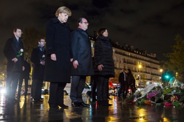 (L-R) German Chancellor Angela Merkel, French President Francois Hollande and Paris Mayor Anne Hidalgo pay their respects to the victims of the November 13 Paris attacks on November 25, 2015, on the Place de la Republic in Paris, where they each left a white rose. Hollande, just off the plane from Washington, met German Chancellor Angela Merkel, seeking support for his faltering effort to forge a coalition to fight Islamic State jihadists. Hollande is expected to look to Merkel to try to ease tensions between Russia and Turkey -- two potential components of the anti-IS alliance -- which fell out over the downing of a Russian warplane at the Turkish-Syrian border. Hollande is on a whirlwind diplomatic tour spurred by the November 13 attacks on Paris that left 130 dead and 350 injured. / AFP / POOL / ETIENNE LAURENT (Photo credit should read ETIENNE LAURENT/AFP/Getty Images)