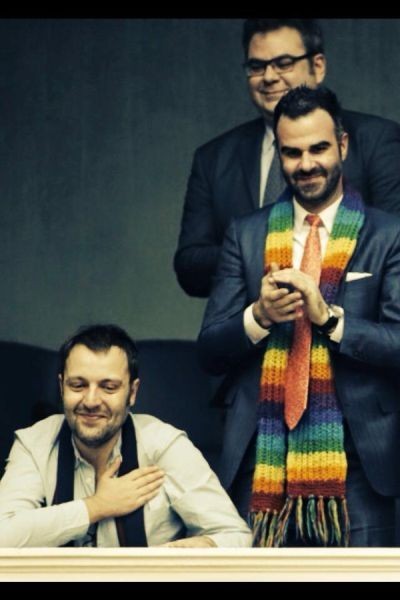 Ο Αύγουστος Κορτώ, καθισμένος, εκφράζει την ευαρέσκεια του. 