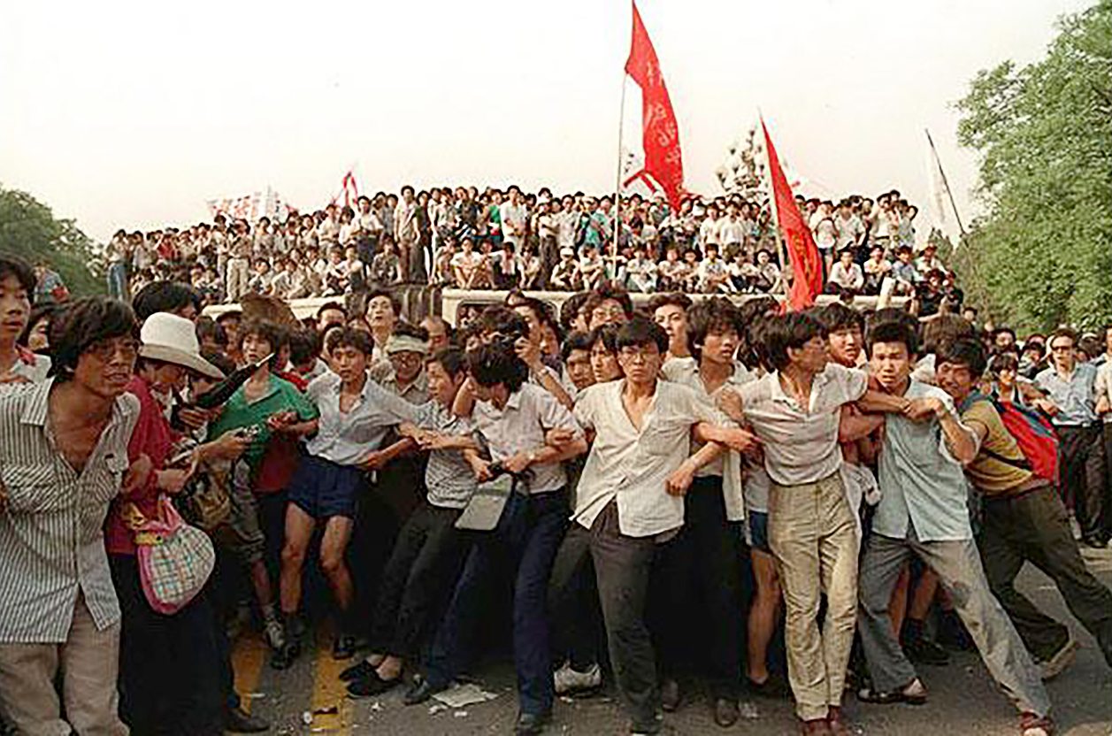 FILE -- Pro-democracy demonstrators link arms to hold back angry crowds from chasing a group of retreating soldiers near the Great Hall of the People in Beijing, China, in this June 3, 1989 file photo. People in the background are atop buses used as roadblock. China appealed to citizens Wednesday June 2, 1999 not to stir up trouble over Friday's 10th anniversary of the crushing of the Tiananmen Square democracy protests. (AP Photo/Mark Avery)