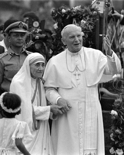 Pope John Paul II holds hands with Mother Teresa after visiting the Casa del Cuore Puro, Mother Teresa's home for the destitute and dying, in the eastern Indian city of Calcutta February 3, 1986. REUTERS/Luciano Mellace/File Photo