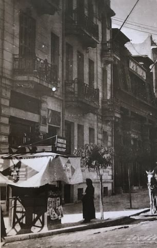 Φωτογραφία τραβηγμένη από τη γωνία Τσιμισκή και Αγίας Σοφίας. Το δεύτερο κτίριο φιλοξενούσε την Ένωση Συντακτών στον πρώτο όροφο, και στο ισόγειο , με την ιδιότυπη αρχιτεκτονική του, τον κινηματογράφο «Διονύσια», όπου το 1938 ο μικρός μαθητής Μανόλης Αναγνωστάκης με την παρέα του έβλεπε ταινία, δίπλα στους προπολεμικούς άσους της ΑΕΚ και του ΠΑΟΚ. 