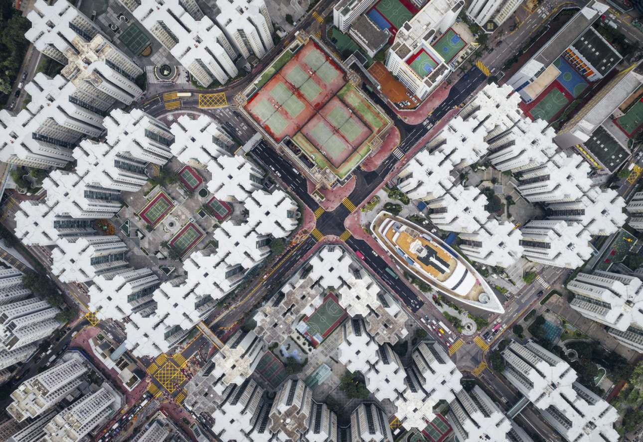 «Περιτειχισμένη Πόλη» - Δεύτερη θέση, κατηγορία Πόλεις. Μέσα στην πυκνοκατοικημένη πόλη του Χονγκ Κονγκ και ανάμεσα στα παράξενα κτίρια με τα ιδιαίτερα μοτίβα κρύβεται μία έκπληξη... ένα εμπορικό κέντρο σε σχήμα καραβιού. Ο φωτογράφος θέλει να δείξει πόσο κλειστοφοβικά είναι να ζεις στο Χονκ Κονγκ από μία διαφορετική γωνία, από ψηλά