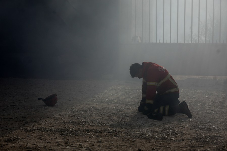 epaselect epa06268200 A firefighter kneels on the ground during a fire in Vila Nova de Poiares, Lousa, Portugal, 15 October 2017. The National Civil Protection Authority (ANPC) said it 'was the worst day of the year in terms of fires', having exceeded 300 forest fires. EPA/PAULO NOVAIS