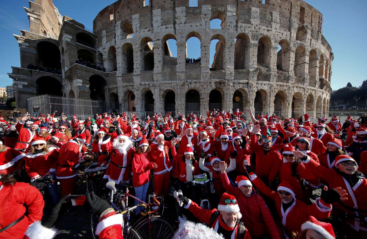 Εκατοντάδες ποδηλάτες με κοστούμια Αϊ-Βασίλη γιορτάζουν έξω από το επιβλητικό Κολοσσαίο της Ρώμης