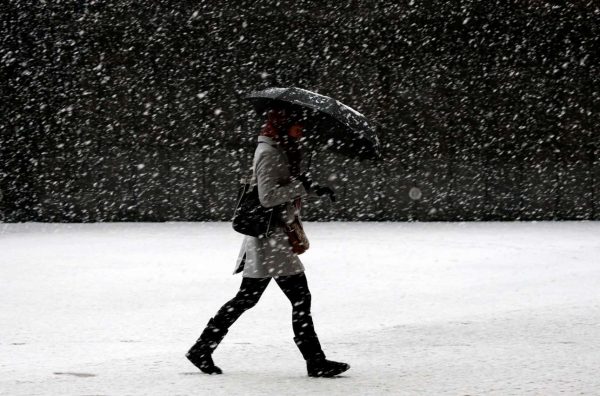 Γυναίκα προσπαθεί να περπατήσει επάνω σε στρώμα χιονιού και πάγου (REUTERS/Francois Lenoir)