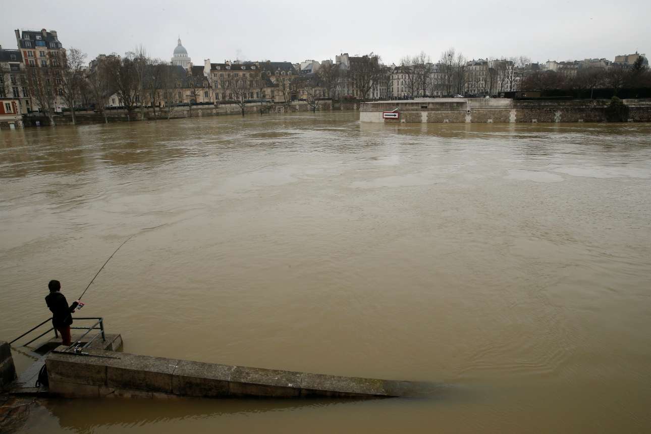 Γυναίκα ψαρεύει στα θολά νερά του ποταμού που διασχίζει την πρωτεύουσα της Γαλλίας