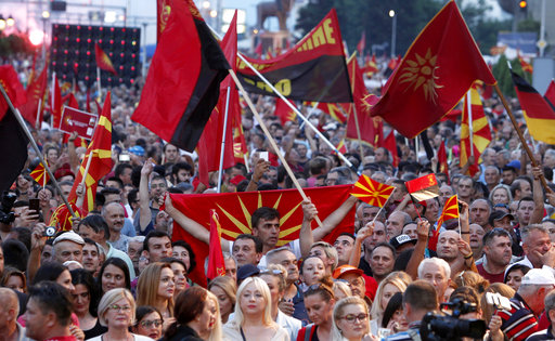 Supporters of the opposition VMRO-DPMNE party wave national, former national flags and party flags during a protest in front of the Government building in Skopje, Macedonia, Saturday, June 2, 2018. Thousands of people gathered Saturday in Skopje on an anti-government protest, organized by the main conservative opposition party. (AP Photo/Boris Grdanoski)
