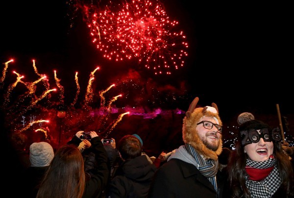 Jordan Pitt and Jess Taylor watch fireworks near Edinburgh Castle during the Hogmanay celebrations in Edinburgh, Scotland, December 31, 2015. REUTERS/Russell Cheyne