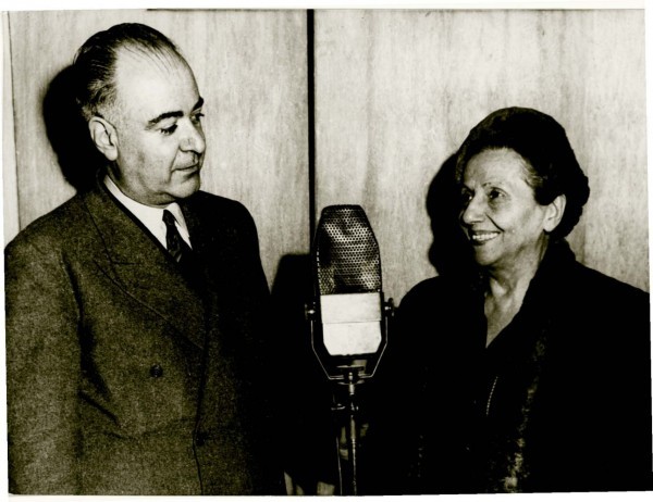 η εναρκτήρια εκπομπή της ιστορικής «Το θέατρο στο μικρόφωνο», που την ξεκίνησε ο δημοσιογράφος Αχιλλέας Μαμάκης το 1953 και συνεχίστηκε για τρεις δεκαετίες. Μετά τον θάνατο του πρώτου διδάξαντα, την εκπομπή συνέχισε η σύζυγός του, χορογράφος Τατιάνα Βαρούτη-Μαμάκη και εκεί κάπου στο 1985 το δημοφιλές «Θέατρο στο μικρόφωνο» έπαψε να ακούγεται και άλλες ομοειδείς εκπομπές συνέχισαν στην ίδια περίπου φόρμα την παρουσίαση προσώπων και γεγονότων του θεάτρου. Για να προσδώσει εγκυρότητα στο ξεκίνημα της εκπομπής του, ο καλλιτεχνικός συντάκτης του Έθνους προσκάλεσε για τη ραδιοφωνική του πρεμιέρα την κορυφαία τραγωδό του θεάτρου μας, Μαρίκα Κοτοπούλη. Αριστερά ο Μαμάκης και δεξιά η Μαρίκα. 