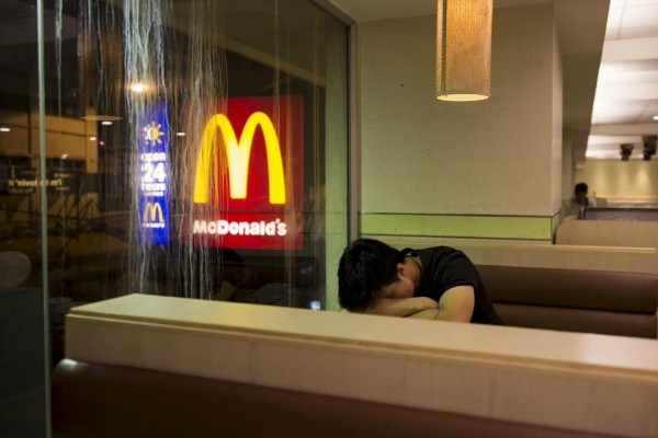 A man sleeps at a 24-hour McDonald's restaurant in Hong Kong, China