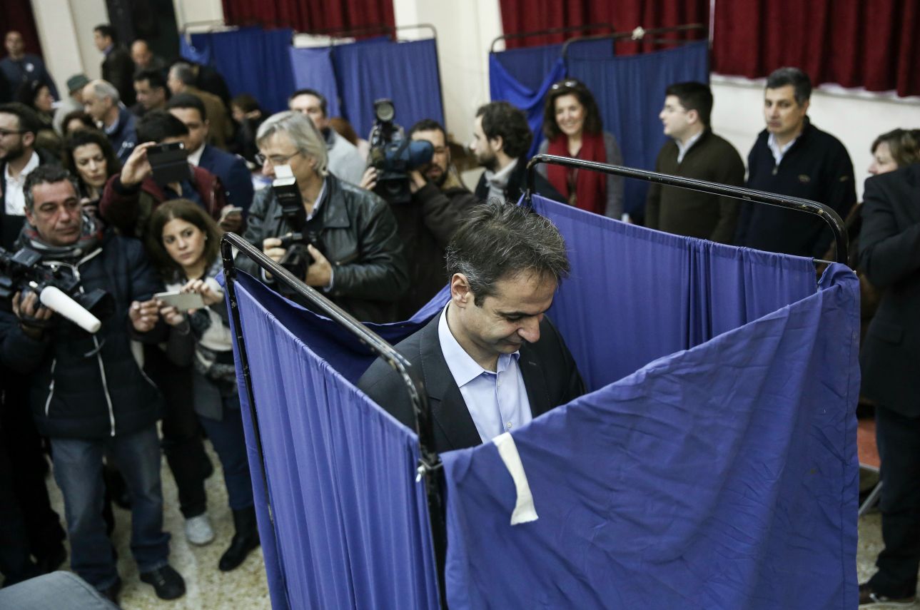 Ο υποψήφιος για την προεδρία Κυριάκος Μητσοτάκης πίσω από το παραβάν. Τον περιμένει ένας μικρός στρατός φωτορεπόρτερ και εικονοληπτών