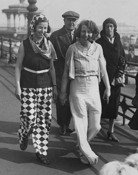 25th March 1932:  Two fair followers, who caused a sensation among holiday makers at Brighton, walking along the front wearing brilliantly coloured beach pyjamas and smoking pipes.  (Photo by Fox Photos/Getty Images)
