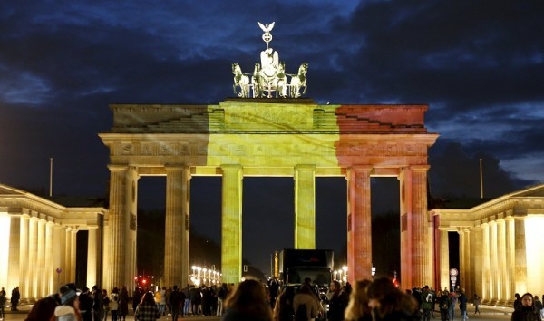 People stand in front of the Brandenburg gate, which is illuminated in black, yellow and red in the colours of the Belgian flag in tribute to victims of Tuesday's attacks in Brussels in Berlin