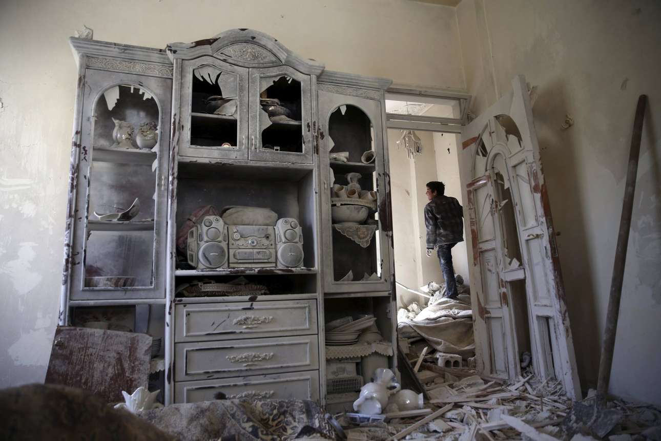 Tα απομεινάρια ενός σπιτιού. Ενα παιδί επιθεωρεί το κατεστραμμένο σπίτι του στην πόλη Δούμα, στη Συρία. Αλλος ένας αναίτιος βομβαρδισμός.