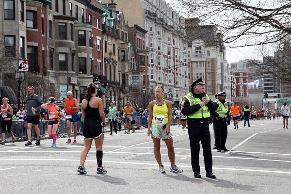 BOSTON, MA - APRIL 15:  Police and runners stand near Kenmore Square after two bombs exploded during the 117th Boston Marathon on April 15, 2013 in Boston, Massachusetts. Two people are confirmed dead and at least 28 injured after at least two explosions went off near the finish line to the marathon.  (Photo by Alex Trautwig/Getty Images)