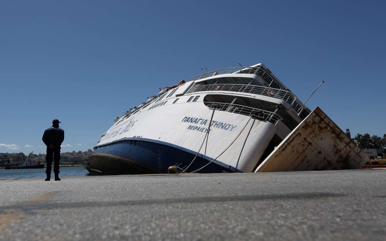 Ο λιμενικός και το μισοβυθισμένο πλοίο. Το «Παναγία Τήνου», που ανήκε στη Ventouris Sea Lines, είχε κατασχεθεί λόγω οικονομικών προβλημάτων.