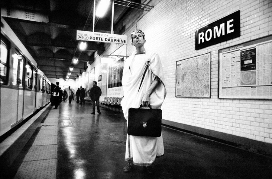 Ενας δαφνοστεφανωμένος Ρωμαίος με χαρτοφύλακα περιμένει στην αποβάθρα. Πού αλλού; Στον σταθμό «Ρώμη», στη Γραμμή 2 στο 8ο Διαμέρισμα του Παρισιού