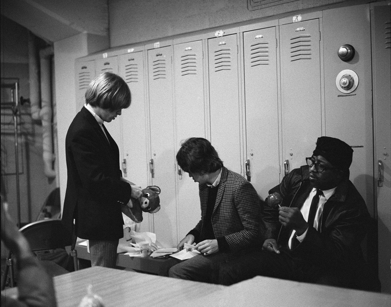 Ο Μπράιαν Τζόουνς και ο Μικ Τζάγκερ ανοίγουν τα γράμματα και δώρα που έχουν στείλει θαυμαστές. Δίπλα τους κάθεται ο θρύλος των Blues, ο Bo Diddley, τρώγοντας ένα καραμελωμένο μήλο