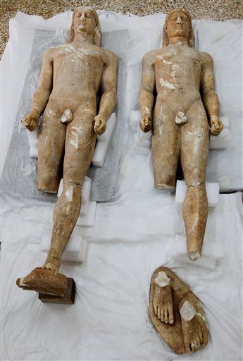 Two illegally excavated ancient male statues recovered from antiquities smugglers in southern Greece are displayed at the National Archaeological Museum in Athens, Tuesday, May 18, 2010. Greek authorities say two farmers have been arrested for allegedly illicitly excavating the statues, which date between 550 and 520 BC, and trying to sell them to a foreign buyer for euros 10 million. Police are seeking a third suspect. (AP Photo/Thanassis Stavrakis)