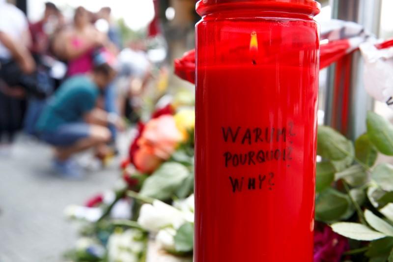 A candle with the words 'Why?' written upon it is placed next to flowers near the Olympia shopping mall, where yesterday's shooting rampage started, in Munich, Germany July 23, 2016.  REUTERS/Arnd Wiegmann
