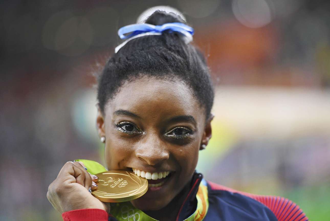 Συμμετείχε πρώτη φορά σε Ολυμπιακούς Αγώνες αλλά κατάφερε να μιλούν όλοι για αυτήν. Η δεκαεννιαχρόνη Αμερικανίδα Σιμόν Μπάιλς δαγκώνει το χρυσό μετάλλιο που κέρδισε στο σύνθετο ατομικό στη γυμναστική