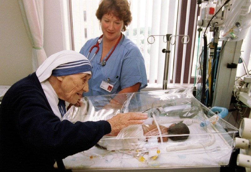 Mother Teresa of Calcutta blesses one week-old Dejen Abreha as nurse-practicioner Trish Fleck looks on in the neo-natal intensive care unit at Saint Margaret's Center for Women and Infants, in Boston, June 15, 1995. REUTERS
