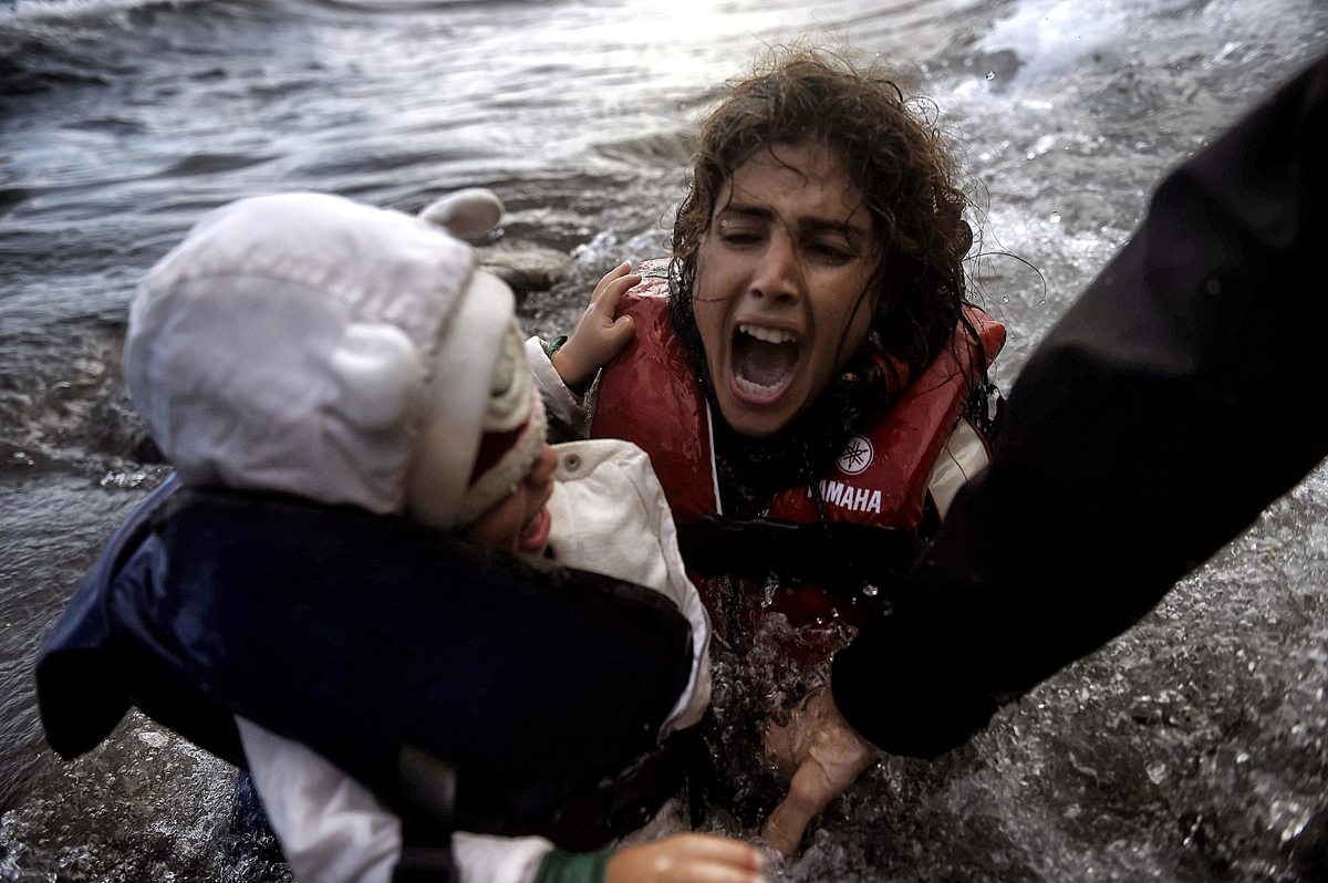 Μια γυναίκα αγκαλιά με το παιδί της φτάνει σε ακτή της Λέσβου έχοντας διασχίσει το Αιγαίο