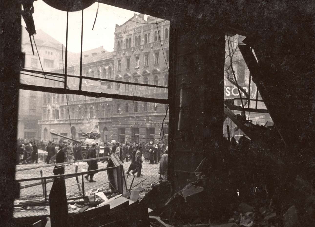 Διαλυμένα καταστήματα και κόσμος στους δρόμους. Το σκηνικό των πρώτων ημερών της εξέγερσης. Στις 4 Νοεμβρίου 1956 μια τεράστια δύναμη 17 σοβιετικών μεραρχιών πεζικού και τεθωρακισμένων περικύκλωσε τη Βουδαπέστη καταπνίγοντας την εξέγερση