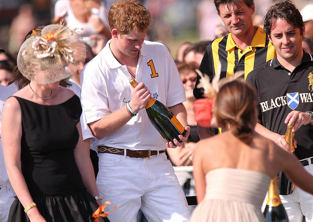 NEW YORK - MAY 30: Prince Harry (2nd-L) is given a magnum of Veuve Cliquot champagne while umpire Anhtony Fanshawe looks on during the awards ceremony following the 2009 Veuve Clicquot Manhattan Polo Classic on Governors Island on May 30, 2009 in New York City. Coinciding with the opening of the Governors Island season and the 400th anniversary of New York, the polo match features Britain's Prince Harry who will play for the Sentebale team against the Black Watch team. All proceeds from the match will benefit American Friends of Sentebale, a charity that supports children in Losotho, Africa. The Prince is visiting the States for only the second time as the first was a private visit when he was a child. (Photo by Michael Loccisano/Getty Images)