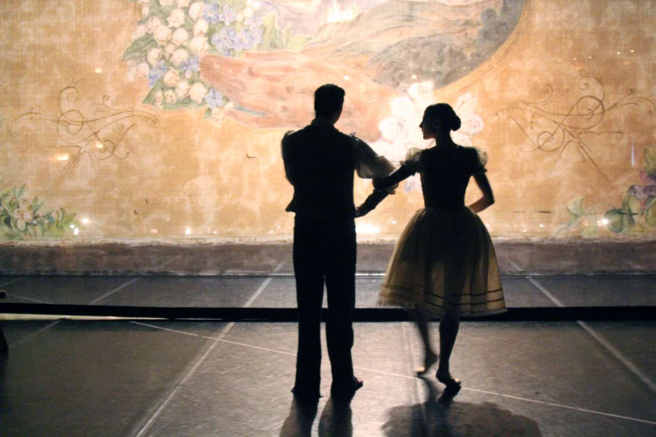 Δύο χορευτές πίσω από την την αυλαία της παράστασης, ένα υπέροχο ζωγραφισμένο τούλι που φέρει στην καρδιά του ένα χέρι
