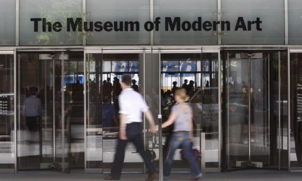 611726-people-walk-past-the-entrance-to-the-museum-of-modern-art-in-new-york