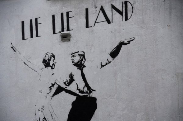 A mural depicting U.S. President Donald Trump dancing with British Prime Minister Theresa May, painted in a style similar to the cinema poster for the film musical "La La Land" is seen on a wall in London, Britain February 18, 2017. REUTERS/Toby Melville FOR EDITORIAL USE ONLY. NO RESALES. NO ARCHIVES.