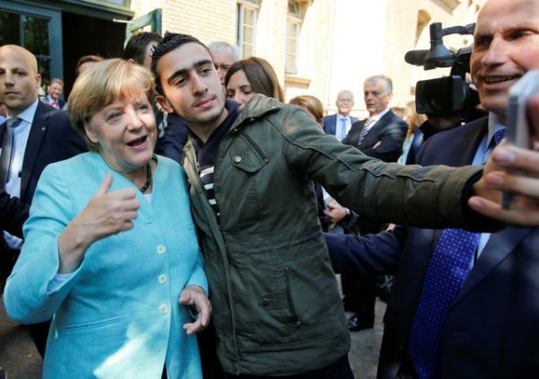 FILE PHOTO: Syrian refugee Anas Modaman takes a selfie with German Chancellor Angela Merkel outside a refugee camp near the Federal Office for Migration and Refugees after registration at Berlin's Spandau district, Germany September 10, 2015. A German court will on February 6, 2017 hold its first hearing in the case of a Syrian refugee who is suing Facebook after the social networking site declined to remove all posts linking him to crimes and militant attacks. REUTERS/Fabrizio Bensch/File Photo