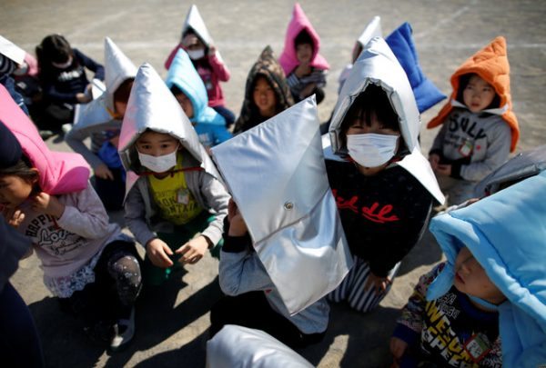 School children wearing padded hoods to protect them from falling debris take part in an earthquake simulation exercise in an annual evacuation drill at an elementary school in Tokyo, Japan March 10, 2017, a day before the six-year anniversary of the March 11, 2011 earthquake and tsunami disaster that killed thousands and set off a nuclear crisis. REUTERS/Issei Kato