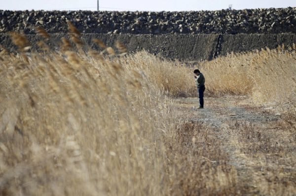 A man prays at the site where a house of his missing colleague once stood, in Ishinomaki, Miyagi prefecture, Japan, in this photo taken by Kyodo March 11, 2017, to mark the six-year anniversary of the March 11, 2011 earthquake and tsunami disaster that killed thousands and set off a nuclear crisis. Mandatory credit Kyodo/via REUTERS ATTENTION EDITORS - THIS IMAGE WAS PROVIDED BY A THIRD PARTY. EDITORIAL USE ONLY. MANDATORY CREDIT. JAPAN OUT. NO COMMERCIAL OR EDITORIAL SALES IN JAPAN. TPX IMAGES OF THE DAY.
