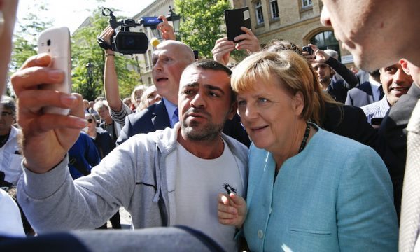 A migrant takes a selfie with German Chancellor Angela Merkel outside a refugee camp near the Federal Office for Migration and Refugees after registration at Berlin's Spandau district, Germany September 10, 2015. REUTERS/Fabrizio Bensch - RTSG48