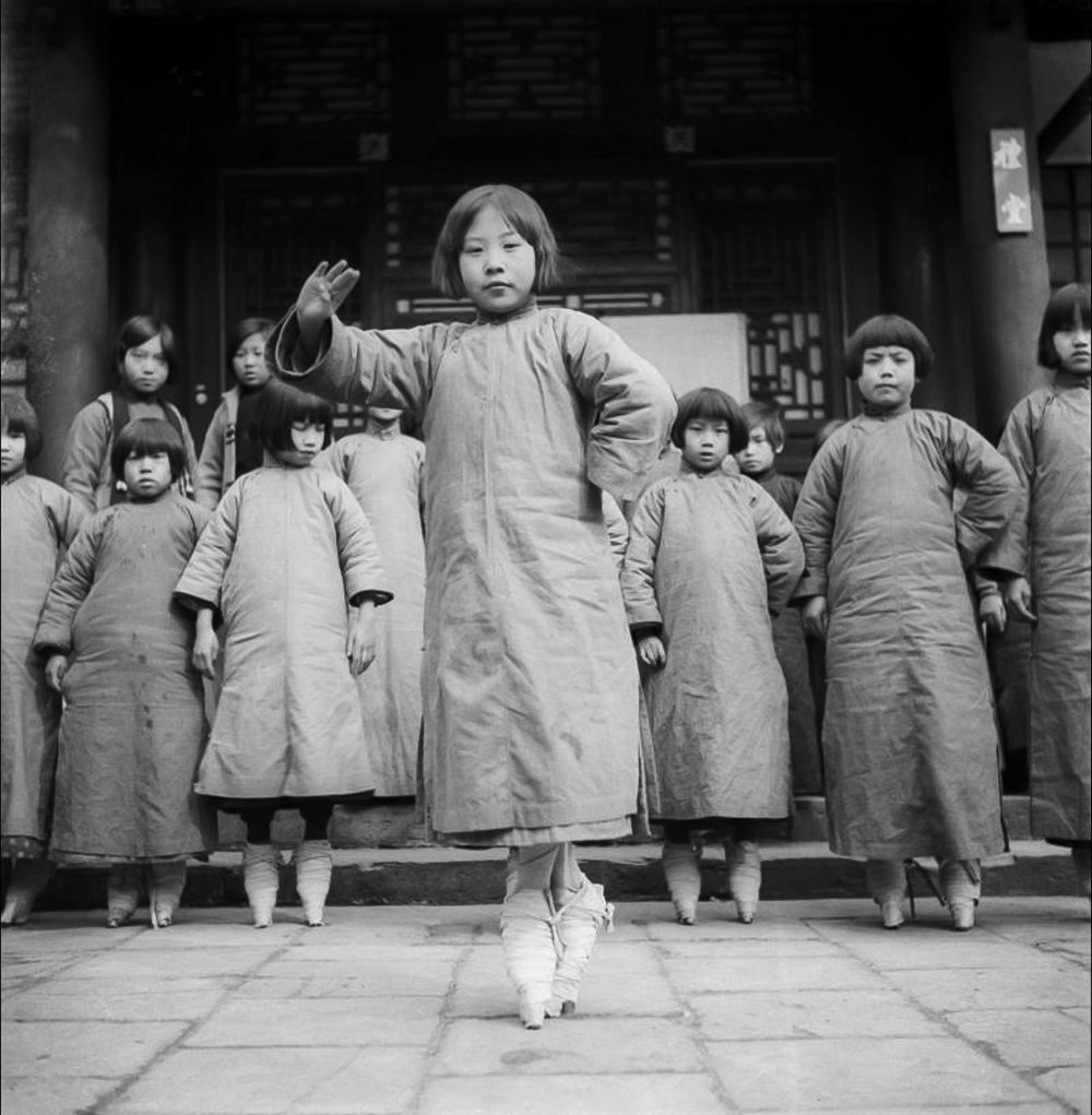 Νεαρά κορίτσια με δεμένα πόδια μαθαίνουν όπερα σε σχολή θεάτρου στο Πεκίνο. Στην τρυφερή ηλικία  των τεσσάρων μέχρι εννέα ετών, κορίτσια υποβάλλονταν στην οδυνηρή πρακτική των δεμένων ποδιών  με σκοπό να προσελκύσουν μνηστήρες.  Η βασανιστική αυτή παράδοση σταμάτησε στις αρχές του 20ου αιώνα