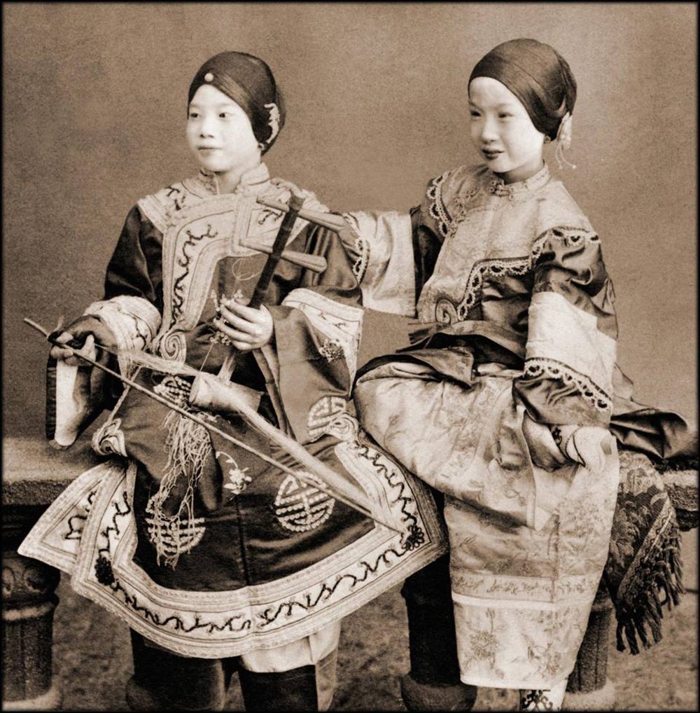 Δύο τραγουδίστριες στο Χονγκ Κονγκ το 1901. Το κορίτσι στα αριστερά κρατάει το παραδοσιακό όργανο «ερχού» (erhu), το οποίο ελάχιστοι μπορούν να παίξουν σήμερα
