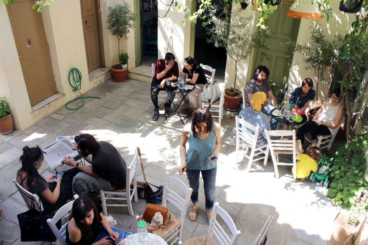 Παρέες και οικογένειες απολαμβάνουν τον μεσημεριανό καφέ στην αυλή του πολυδιάστατου, καλλιτεχνικού χώρου το «Βρυσάκι» (Βρυσακίου 17)