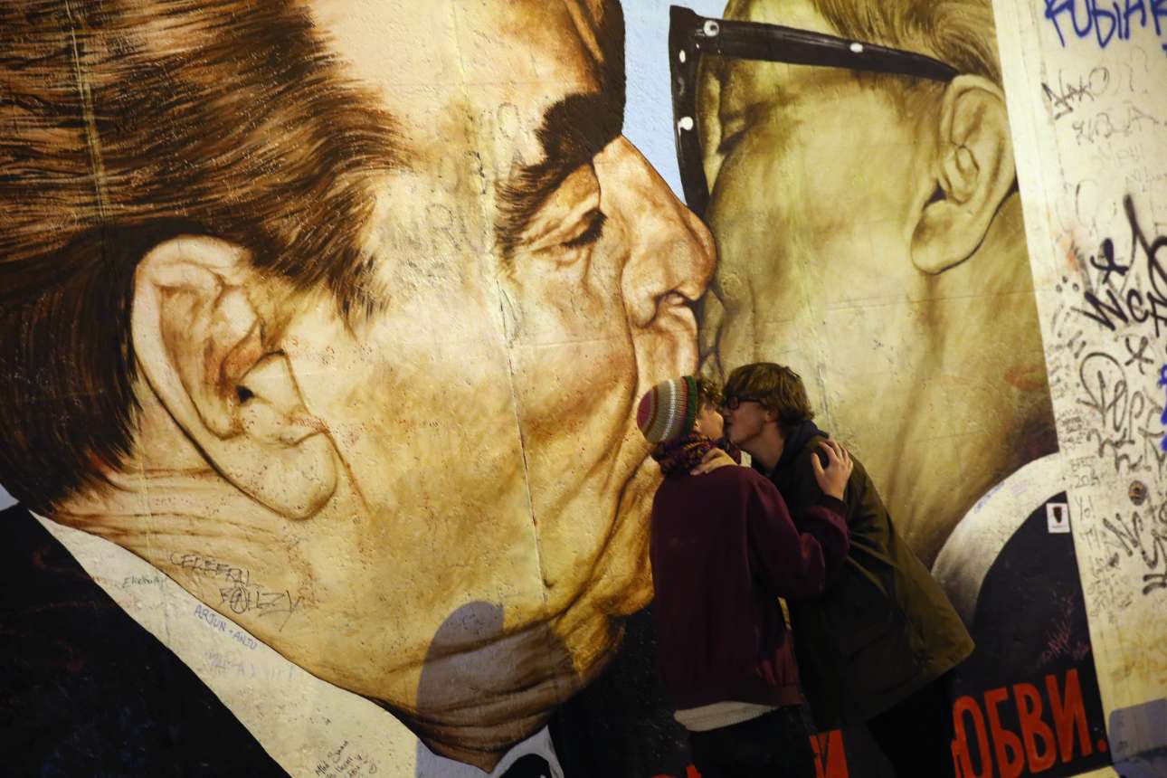 Η εικόνα στον τοίχο είναι διάσημη. Ο Μπρέζνεφ φιλάει τον Χόνεκερ το 1979, για τα 30άχρονα της Λαοκρατικής Δημοκρατίας της Γερμανίας. Αυτό το φιλί τώρα κοσμεί το τοίχος του Βερολίνου και είναι το τέλειο φόντο για σέλφι… Οι δύο νεαροί Σουηδοί στη φωτογραφία το αποδεικνύουν.