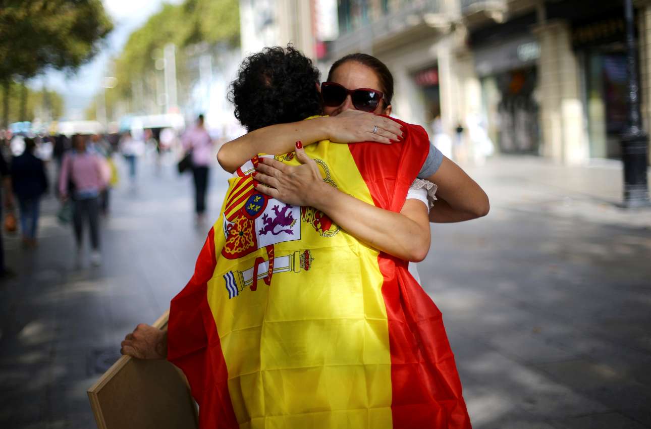 Νεαρός με σημαία της Ισπανίας προσφέρει δωρεάν αγκαλιές στους δρόμους της Βαρκελώνης
