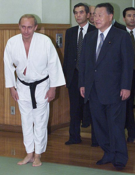 377738 03: Russian President Vladimir Putin in judo gear, escorted by Japanese Prime Minister Yoshiro Mori, right, bows before entering Kodokan judo hall in Tokyo, September 5, 2000. For the second time in less than two months, Putin, who has a black belt in the sport, donned his judo gear in Japan. (Pool Photo/Liaison)
