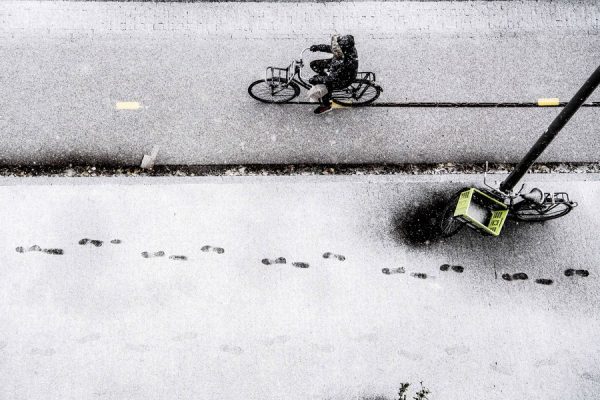 epa06381377 A man on a bike slowly drives along a snowy road in Rotterdam, The Netherlands, 10 December 2017. Weather warnings have been issued after heavy snow affected large areas of the country. EPA/ROBIN UTRECHT