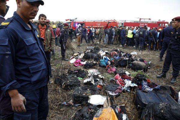 epa06598135 Officials look at belongings of passengers at the site of the plane crash at the main airport Tribhuvan International Airport in Kathmandu, Nepal, 12 March 2018. According to reports, Bangladeshi US-Bangla plane had crashed while landing at the airport with 71 passengers and crew onboard. According to Nepalese officials at least 40 people have been killed and at least 22 survived the crash. EPA/NARENDRA SHRESTHA
