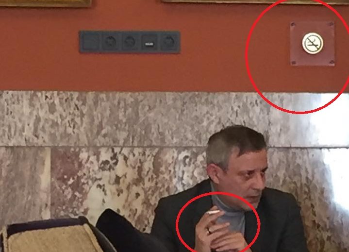 Ποιος νόμος; Ο Βέττας του ΣΥΡΙΖΑ καπνίζει κάτω από το σήμα τού απαγορεύεται το κάπνισμα!