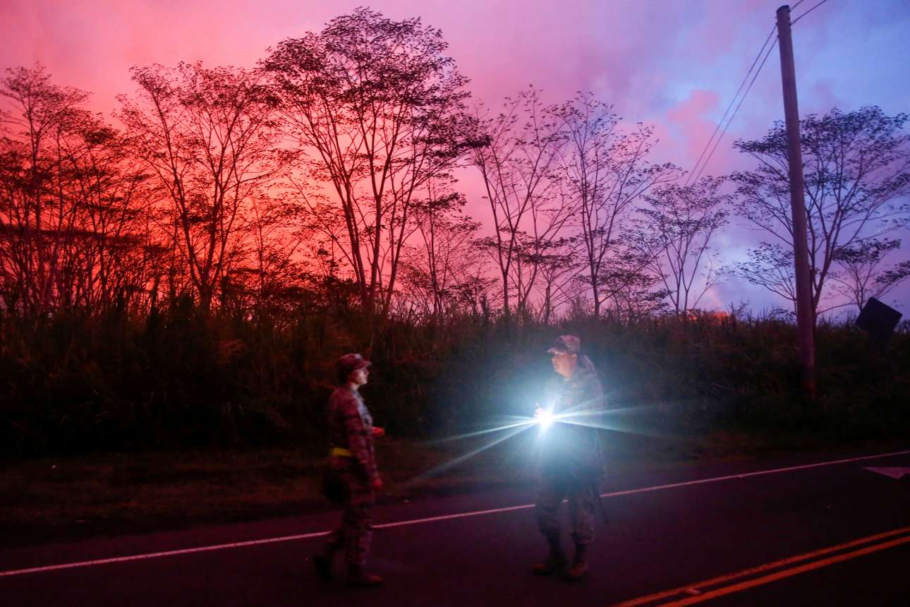 Παρασκευή, 8 Ιουνίου, Χαβάη. Δύο εθνοφύλακες περιπολούν στην Παχόα ενώ η λάβα από το ηφαίστειο Κιλαουέα χαρίζει ένα απόκοσμο χρώμα στον ουρανό