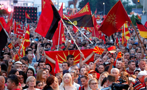 Supporters of the opposition VMRO-DPMNE party wave national, former national flags and party flags during a protest in front of the Government building in Skopje, Macedonia, Saturday, June 2, 2018. Thousands of people gathered Saturday in Skopje on an anti-government protest, organized by the main conservative opposition party. (AP Photo/Boris Grdanoski)