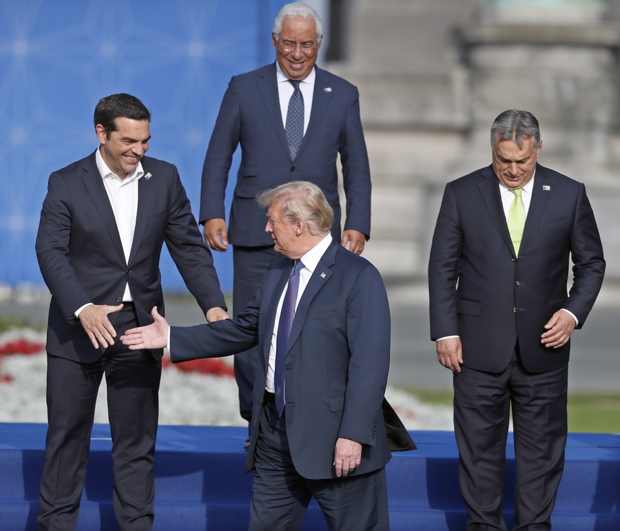 epa06881860 Greece's Prime Minister Alexis Tsipras (L) greets US President Donald J. Trump during a family photo as Portugal's Prime Minister Antonio Costa (top) and Hungary's Prime Minister Viktor Orban (R) look on during a NATO Summit in Brussels, Belgium, 11 July 2018. NATO member countries' heads of states and governments gather in Brussels on 11 and 12 July 2018 for a two days meeting. EPA/IAN LANGSDON
