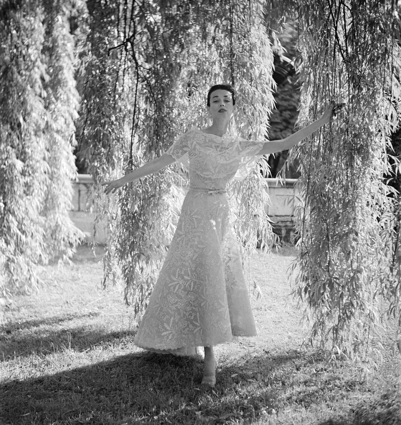 Μοντέλο ποζάρει κάτω από μία ιτιά φορώντας ένα παραμυθένιο φόρεμα από δαντέλα Chanel 