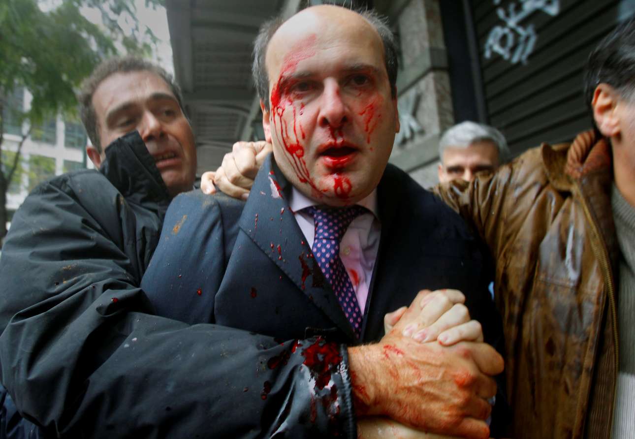 Ο Γιάννης Μπεχράκης κάλυψε εκτενώς και την ελληνική κρίση: εδώ, τον Δεκέμβριο του 2010, μεταφέρει την εικόνα του πρώην υπουργού Κωστή Χατζηδάκη μετά την επίθεση που δέχθηκε από «Αγανακτισμένους» στο Σύνταγμα